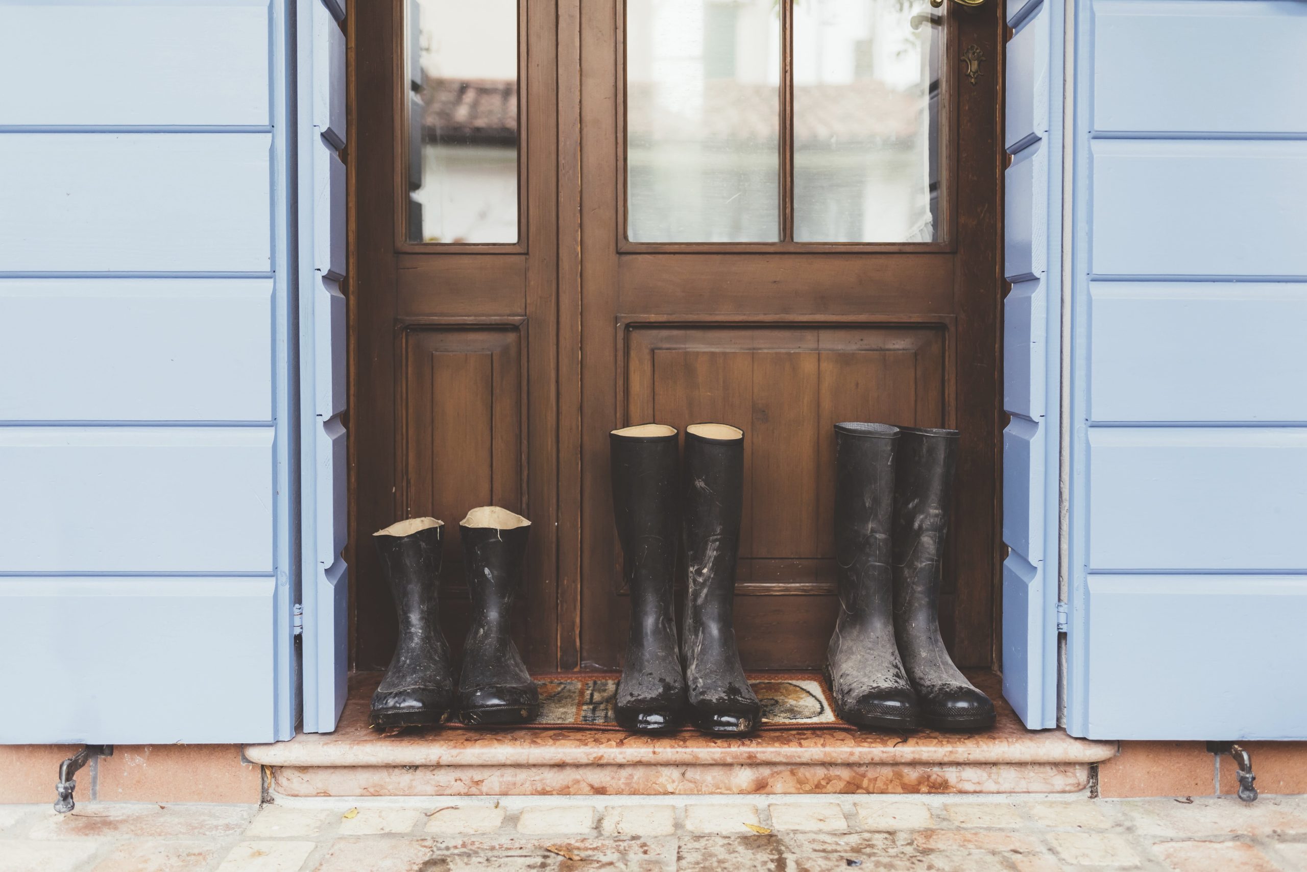 three-pairs-of-rubber-boots-on-doorstep-2024-06-21-18-42-21-utc